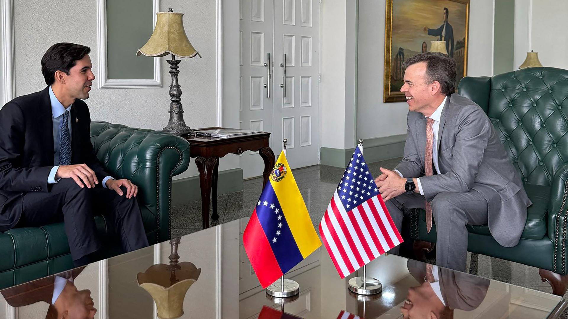 Handout der US-Botschaft in Venezuela: Links ist der venezolanische Rektor für Europa und Nord-Amerika, Oliver Blanco, zu sehen und rechts der neue US-Geschäftsträger John Barrett. Sie sitzen sich auf Sofas gegenüber.