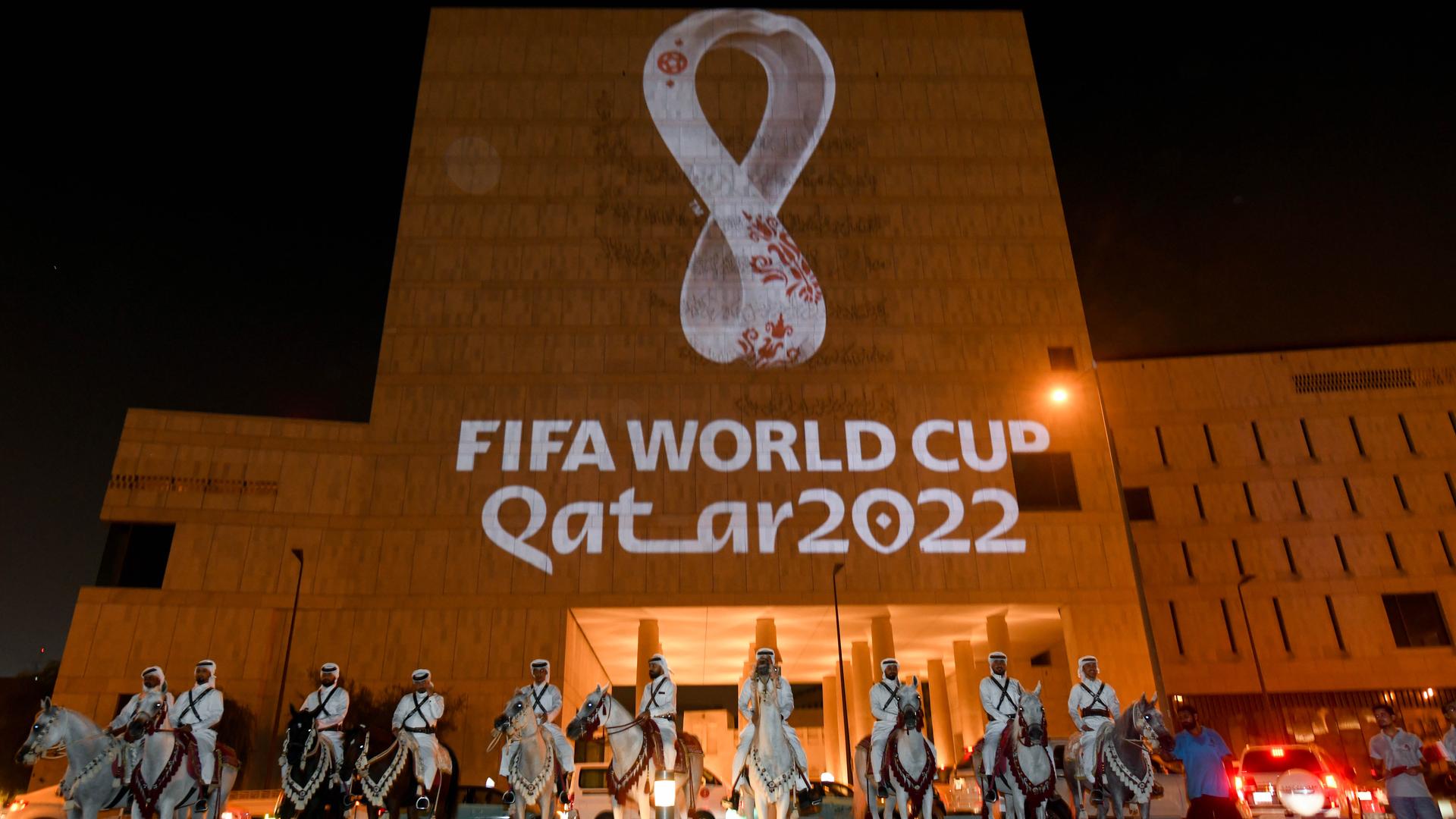 Das Logo von der Fußball-Welt-Meisterschaft 2022 in Katar wird an eine Haus-Wand projiziert.
