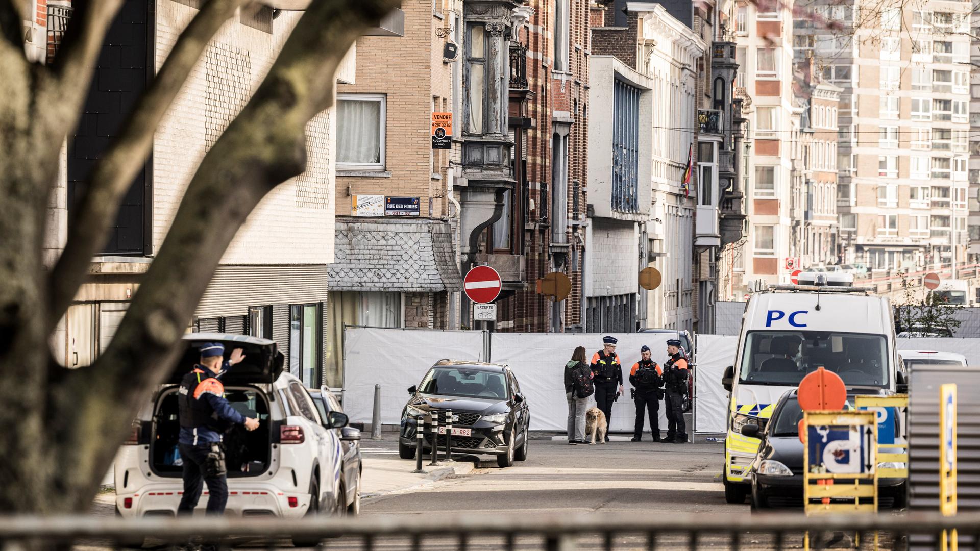 Polizisten stehen an Absperrungen und sichern ein Gebiet nach einer Explosion in der Nähe einer Synagoge in Lüttich. 