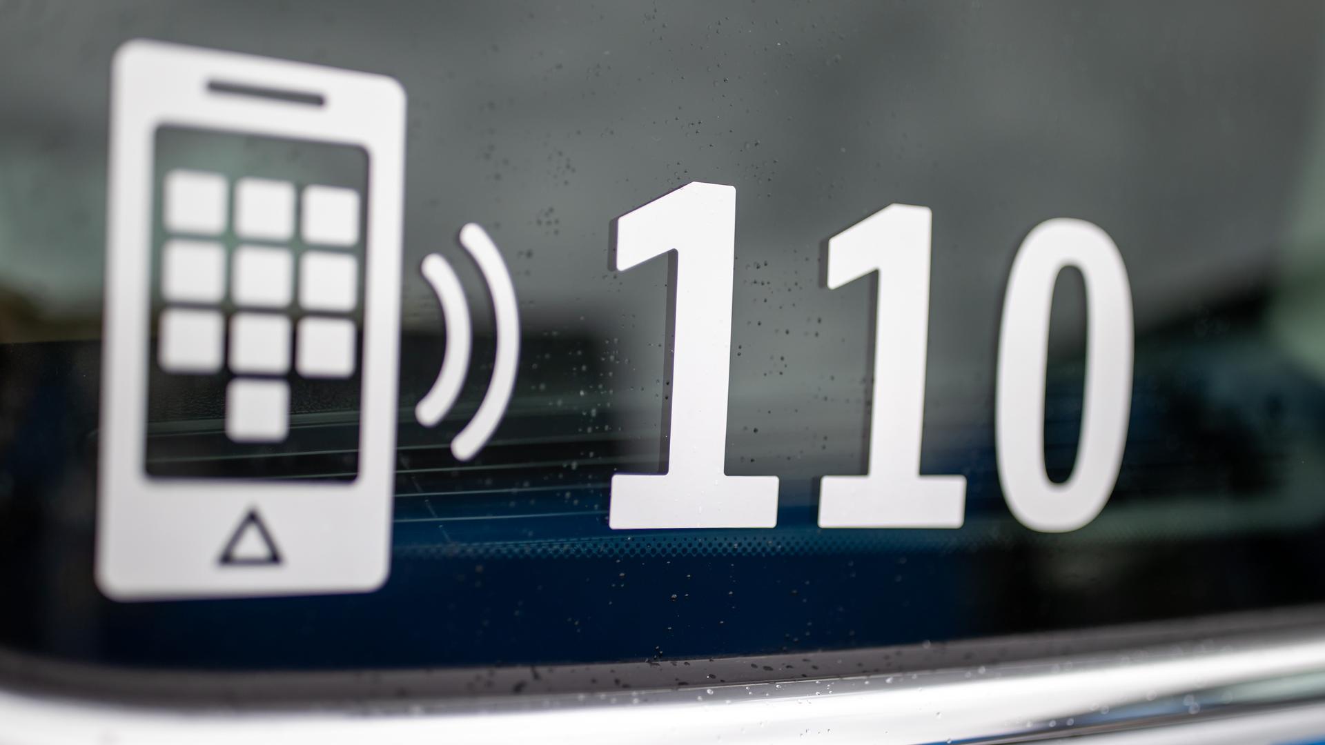Die Nummer des Polizeinotrufs 110 steht auf der Scheibe eines Polizeifahrzeugs. Die Nummer des Polizeinotrufs 110 steht auf der Scheibe eines Polizeifahrzeugs.