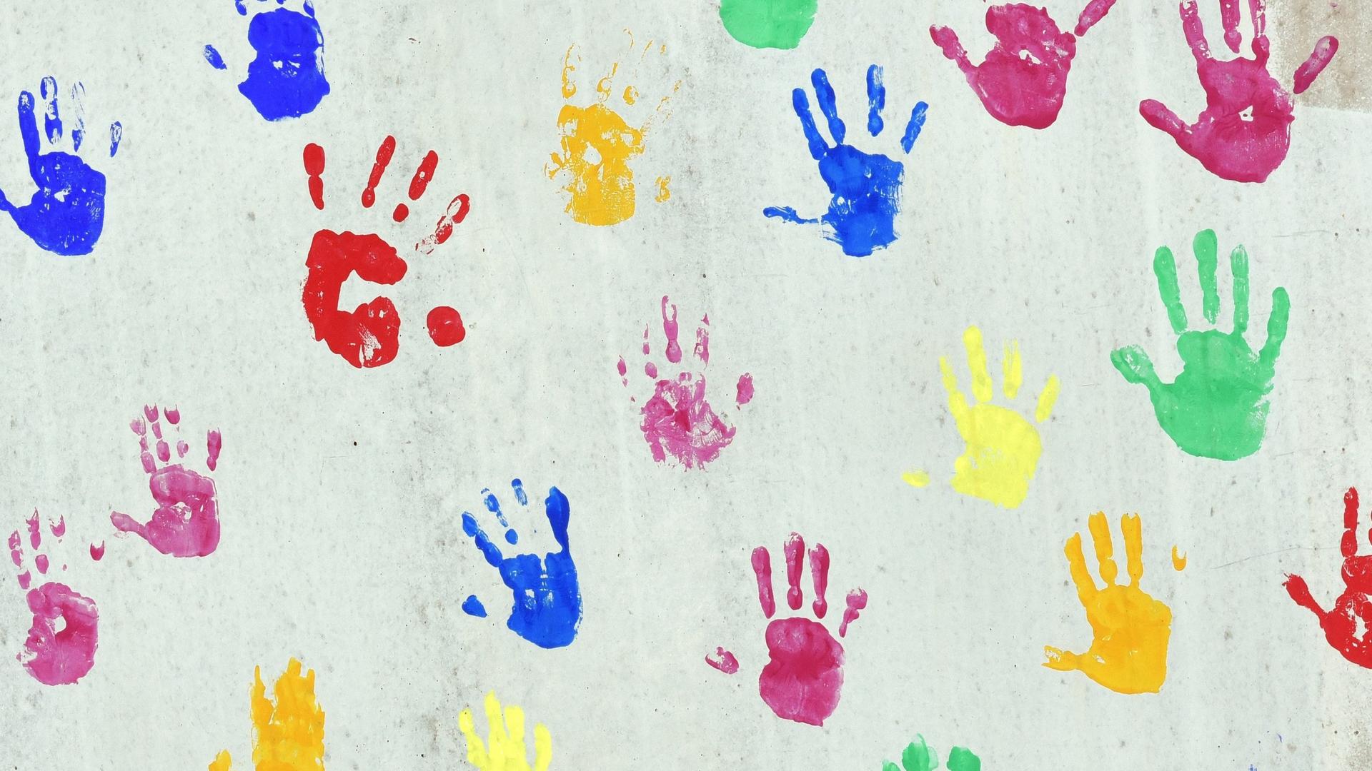 Bunte Handabdrücken auf einer bemalte Wand einer Kindertagesstätte. Bunte Handabdrücken auf einer bemalte Wand einer Kindertagesstätte.