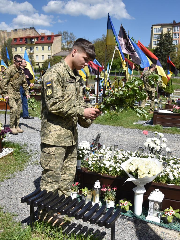 Ein Soldat legt Blumen ab Grab eines gefallenen Kameraden nieder.