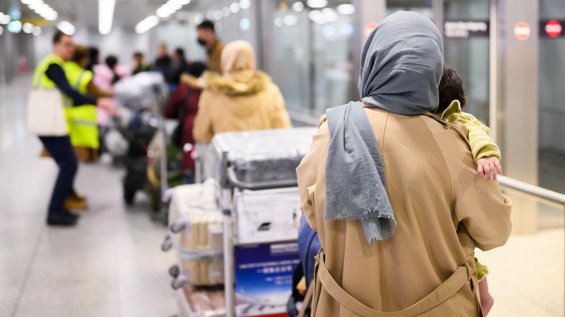 Afghaninnen und Afghanen aus den Bundesaufnahmeprogrammen stehen im Flughafen Hannover. Afghaninnen und Afghanen aus den Bundesaufnahmeprogrammen stehen im Flughafen Hannover.