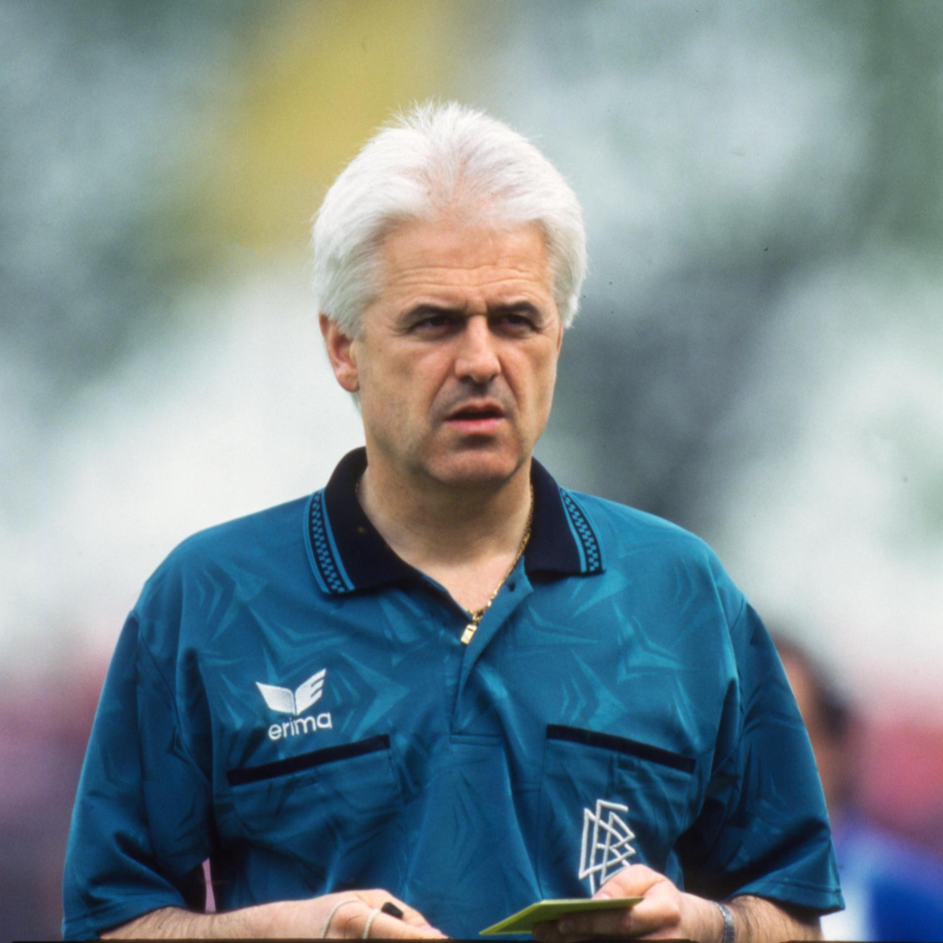 Eugen Strigel als Schiedrichter in der Fußballbundesliga während der Saison 1994/95. Er hat eine gelbe Karte in der Hand.