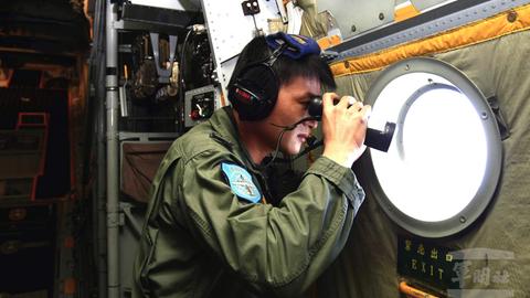 Ein Mann schaut mit einem Fernglas durch ein Flugzeugfenster nach draußen.