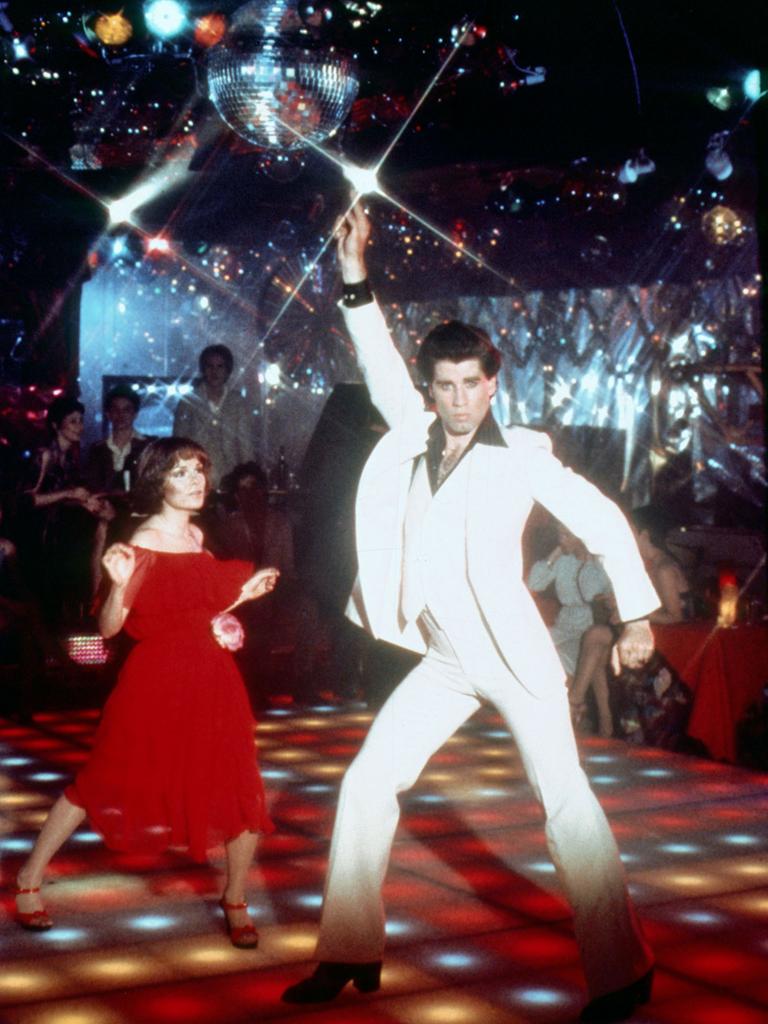 Ein Mann und eine Frau tanzen unter einer Discokugel.
