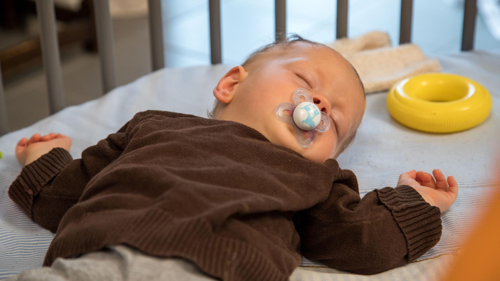 Ein Baby schläft in einem Kinderbett. Ein Baby schläft in einem Kinderbett.