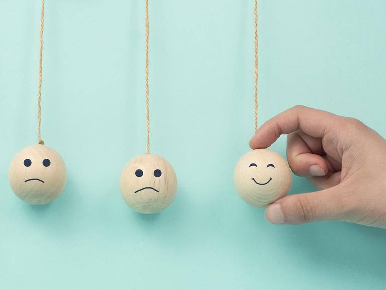 Pedelkugeln: Glückliches lächelndes Gesicht verbreitet Glück in traurigen Gesichtern 