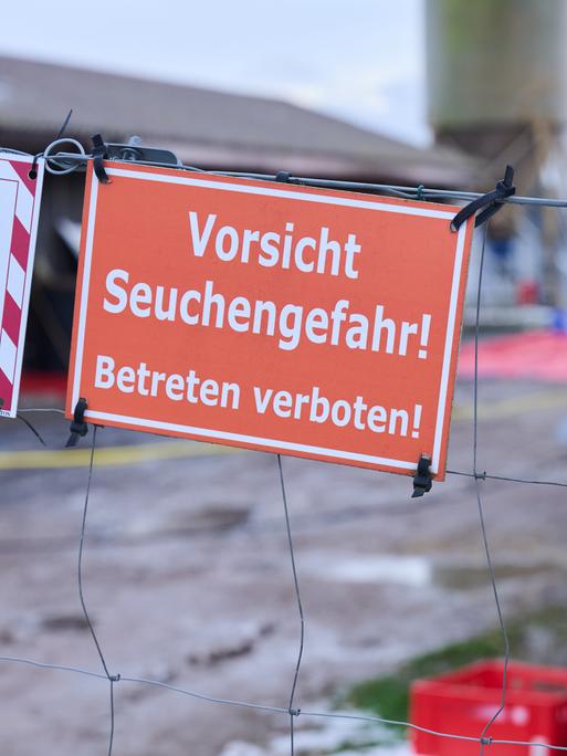 Am Tor zum Gelände eines Bauernhofs hängt ein Schild mit der Aufschrift "Vorsicht Seuchengefahr! Betreten verboten".