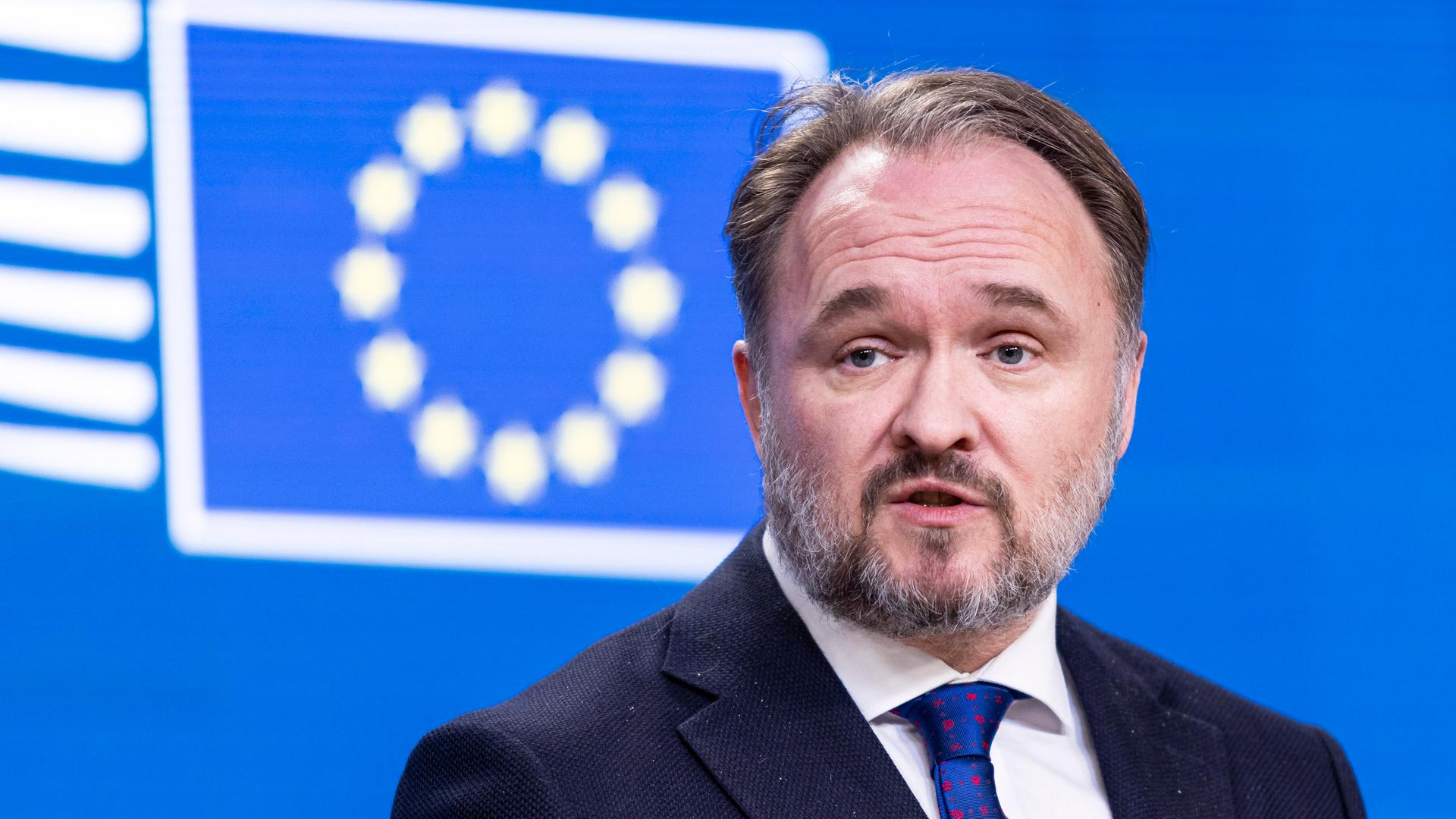 Dan Jorgensen steht vor einem blauen Hintergrund mit der Flagge der EU. Dan Jorgensen steht vor einem blauen Hintergrund mit der Flagge der EU.