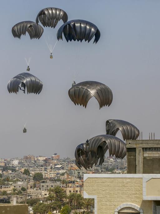 Fallschirme tragen Hilfgüter aus der Luft in den Gazastreifen. 
