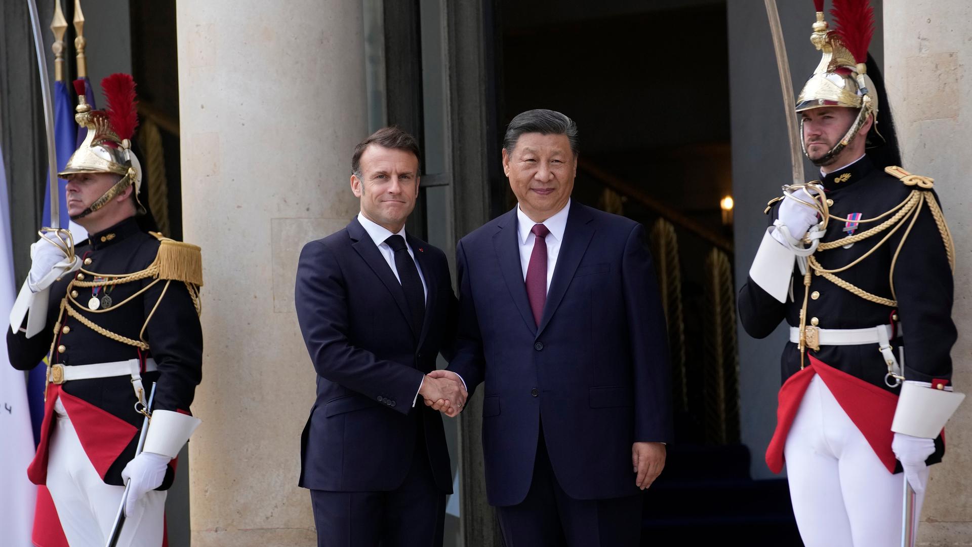 Der französische Präsident Emmanuel Macron gegrüßt Chinas Präsident Xi Jinping vor dem Elysee Palast in Paris. 