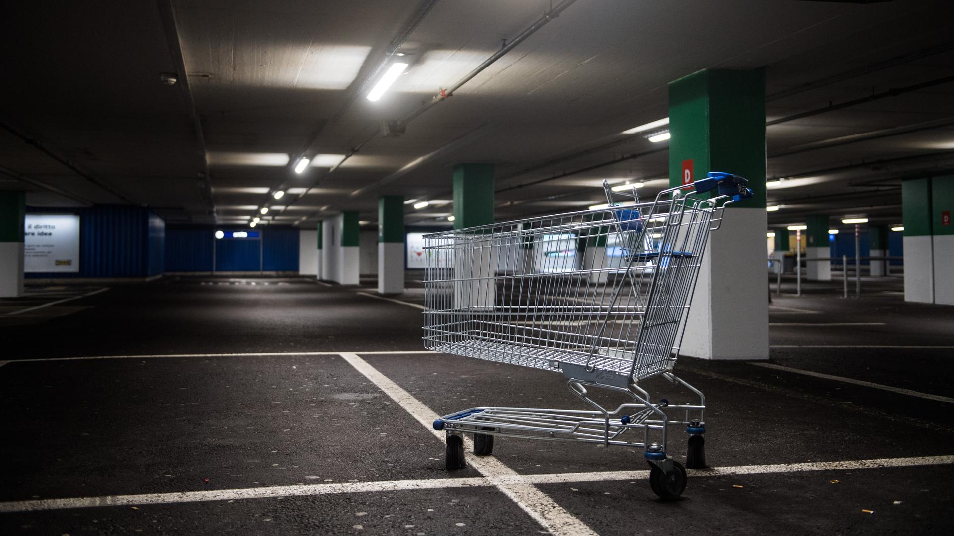 Ein Einkaufswagen steht im leeren Parkhaus