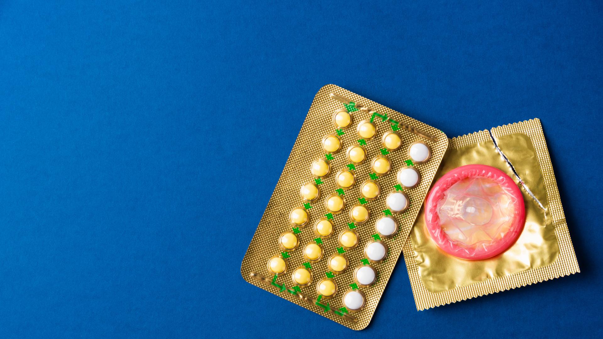 World sexual health or Aids day, condom on wrapper pack and contraceptive pills blister hormonal birth control pills, st