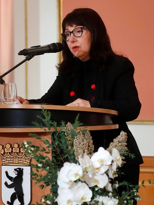 Petra Rosenberg steht an einem Pult der Stadt Berlin am Mikrofon