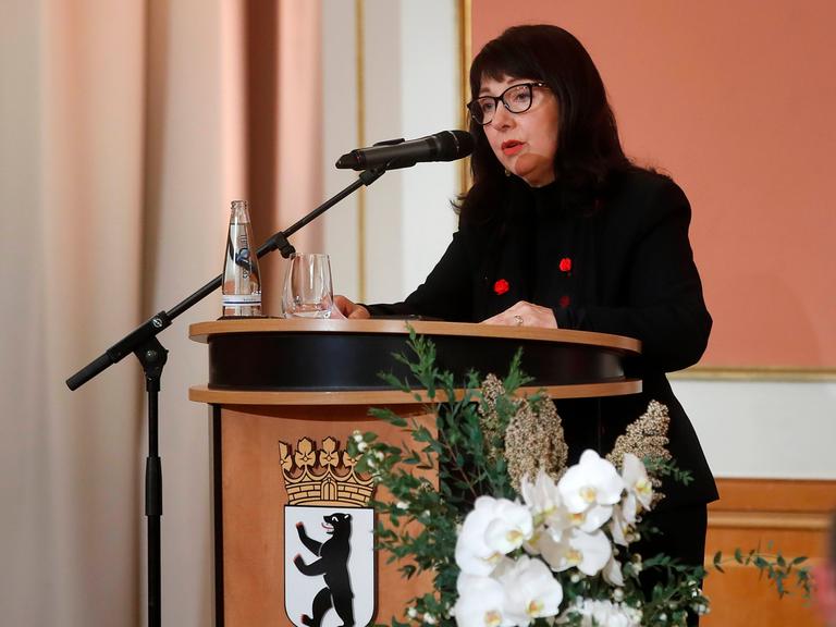 Petra Rosenberg steht an einem Pult der Stadt Berlin am Mikrofon