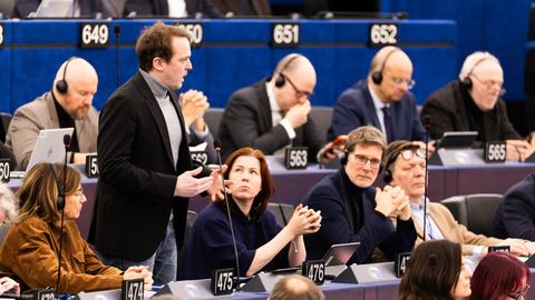 Der Grünen-Europaabgeordnete Erik Marquardt steht im Gebäude des europäischen Parlaments und spricht. 