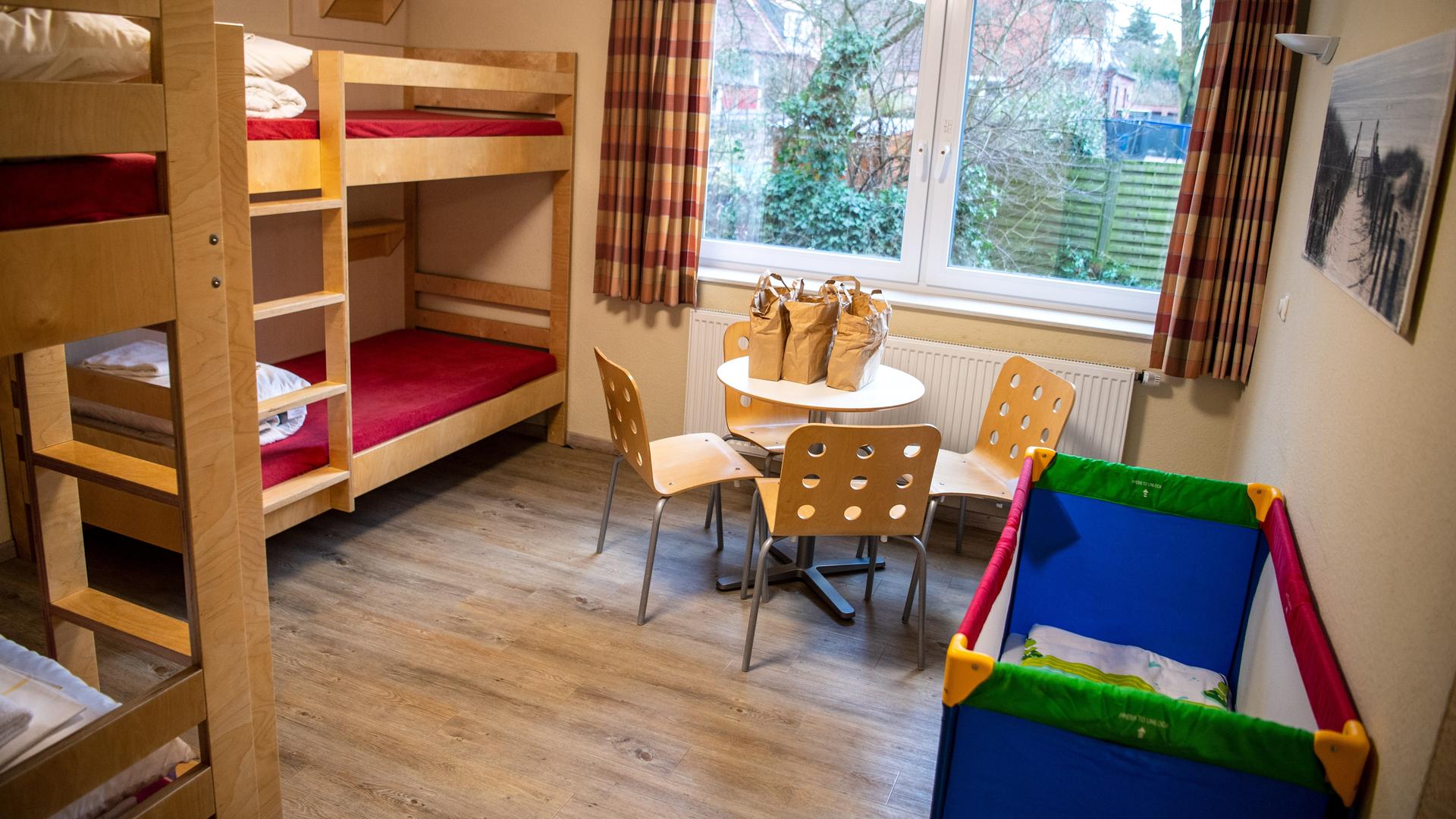 Ein Gästezimmer mit Stockbetten und einem Kinderbett in einer Jugendherberge