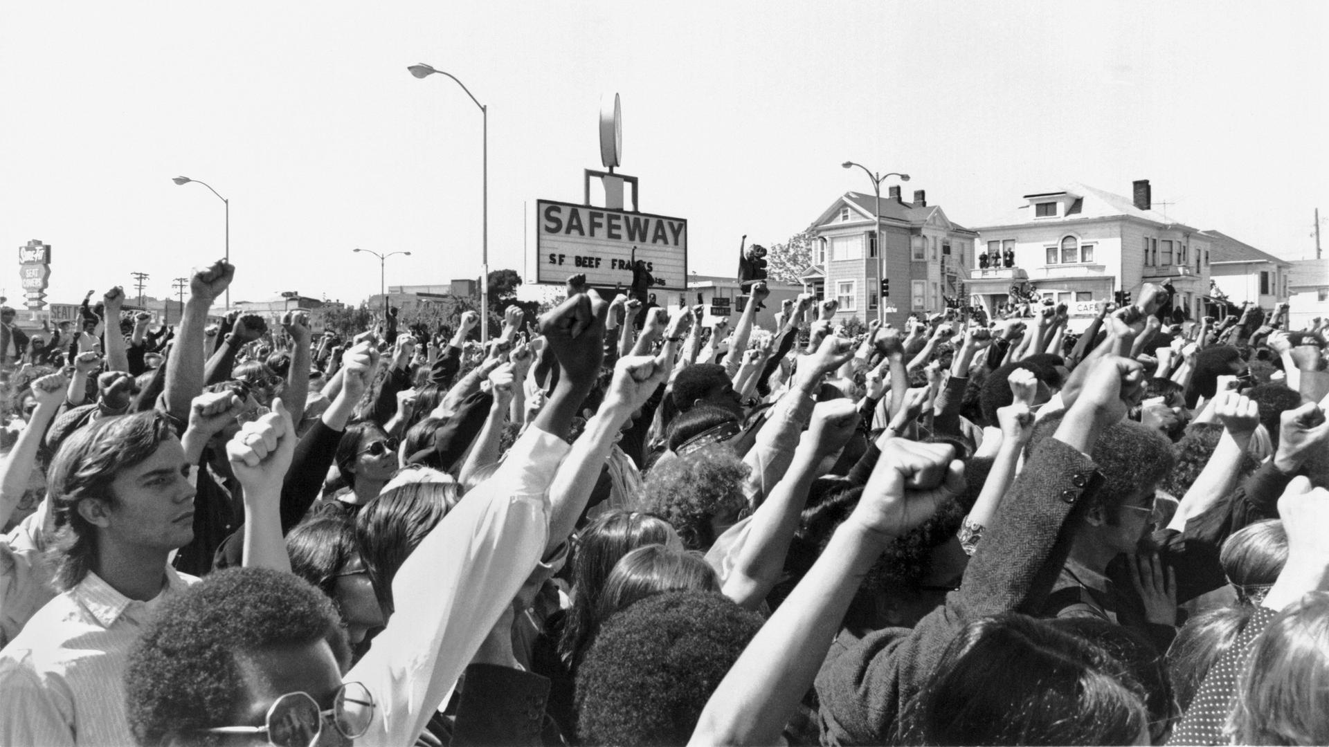 Schwarz-weiß Foto: Menschen recken Fäuste in die Höhe.