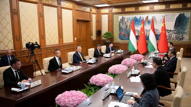 Der ungarische Ministerpräsident Orban sitzt dem chinesischen Staatschef Xi Jinping in Peking gegenüber. Neben ihnen sitzen jeweils mehrere Personen. 