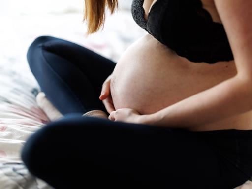 Eine schwangere Frau hält ihren Bauch Eine schwangere Frau hält ihren Bauch