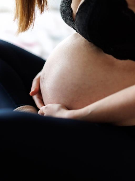 Eine schwangere Frau hält ihren Bauch Eine schwangere Frau hält ihren Bauch