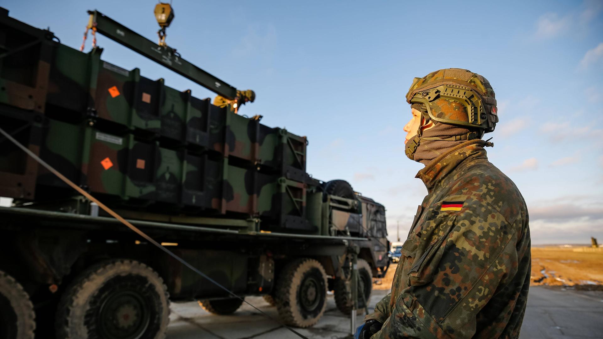 Ein deutscher Bundeswehrsoldat bereitet ein Fahrzeug für die Verladung vor. 