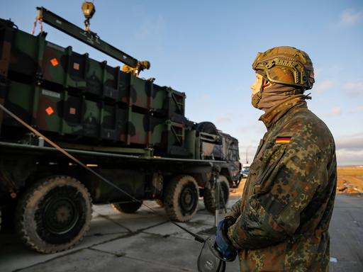 Ein deutscher Bundeswehrsoldat bereitet ein Fahrzeug für die Verladung vor. 