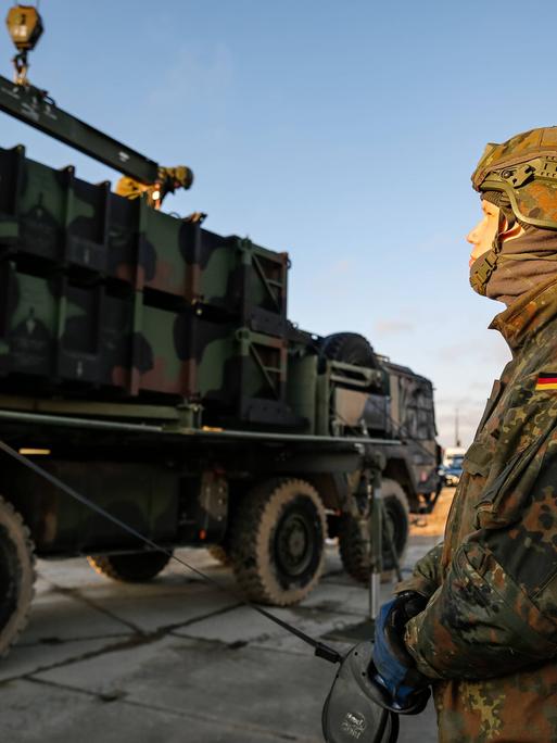 Ein deutscher Bundeswehrsoldat bereitet ein Fahrzeug für die Verladung vor. 