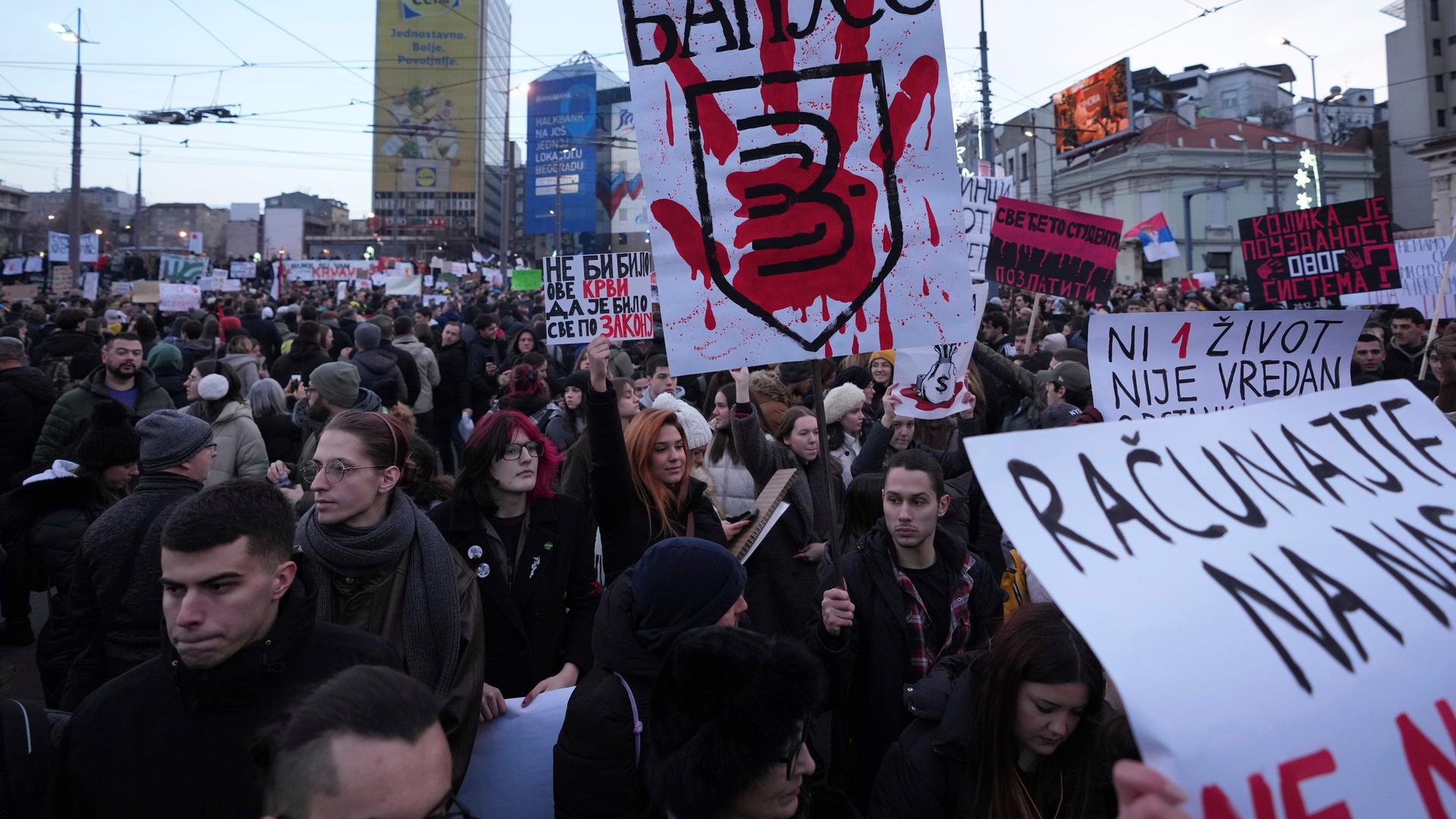 Menschen nehmen mit Plakaten an einem Protest gegen die serbischen Behörden in Belgrad teil.