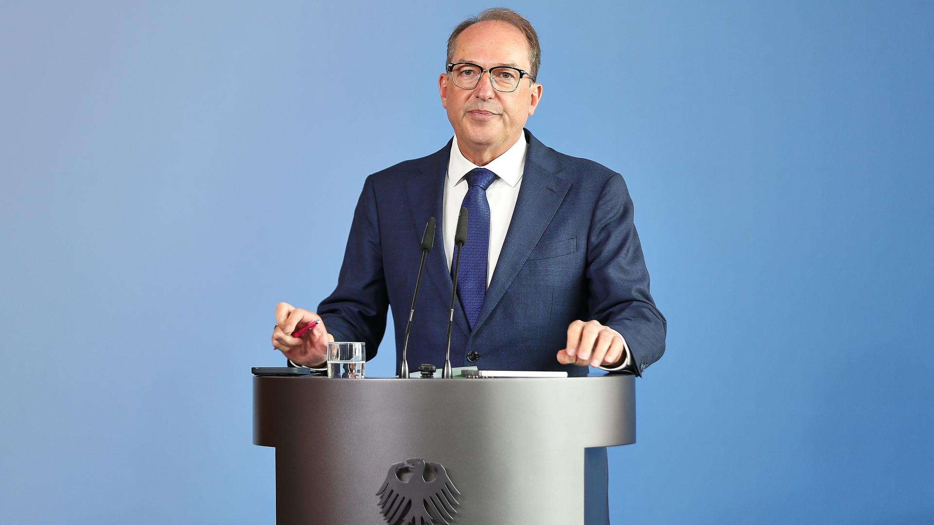 Bundesminister des Innern Alexander Dobrindt (CSU) steht hinter einem silbernen Rednerpult, auf dem der Adler zu sehen ist.