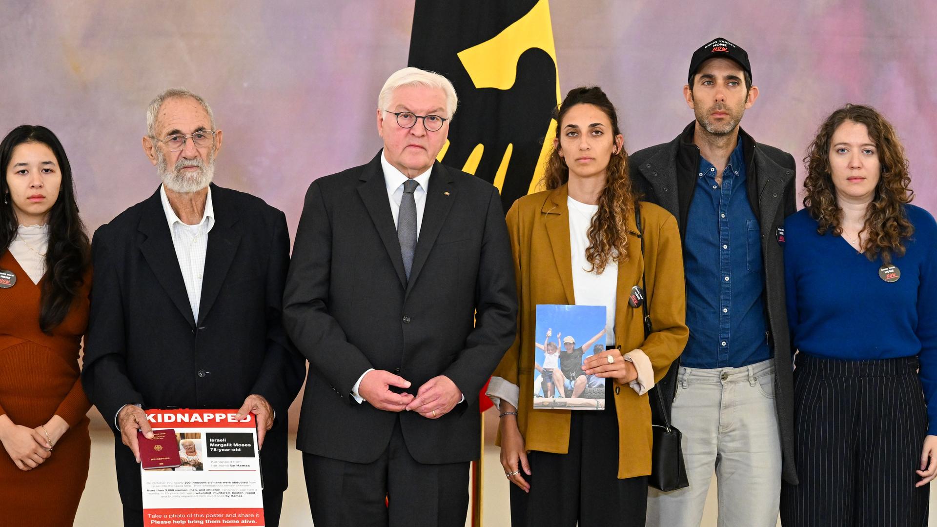 Bundespräsident Frank-Walter Steinmeier steht im Schloss Bellevue neben den Familienangehörigen von nach Gaza verschleppten deutsch-israelischen Bürgern.