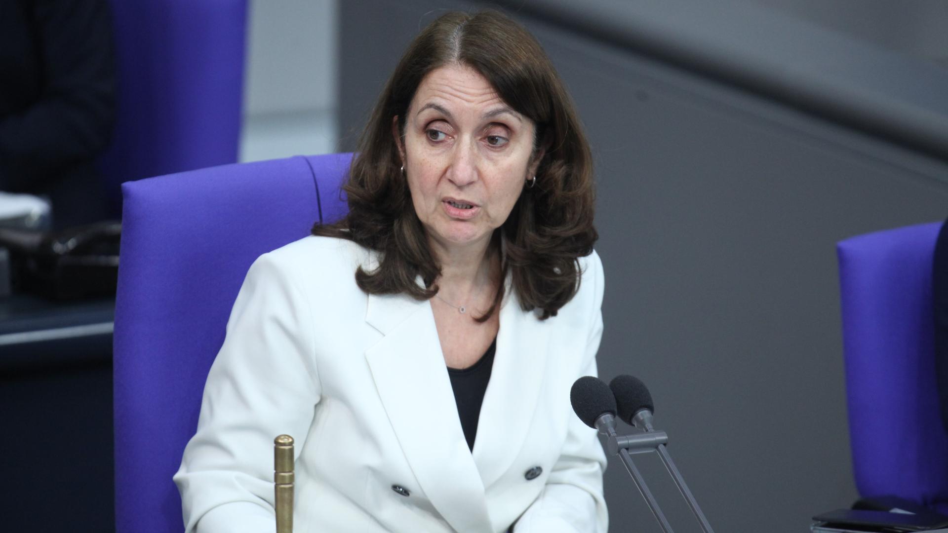 Die SPD Politikerin Aydan Özoguz sitzt auf einem blauen Stuhl im Bundestag und spricht in Mikrofone. Die SPD Politikerin Aydan Özoguz sitzt auf einem blauen Stuhl im Bundestag und spricht in Mikrofone.