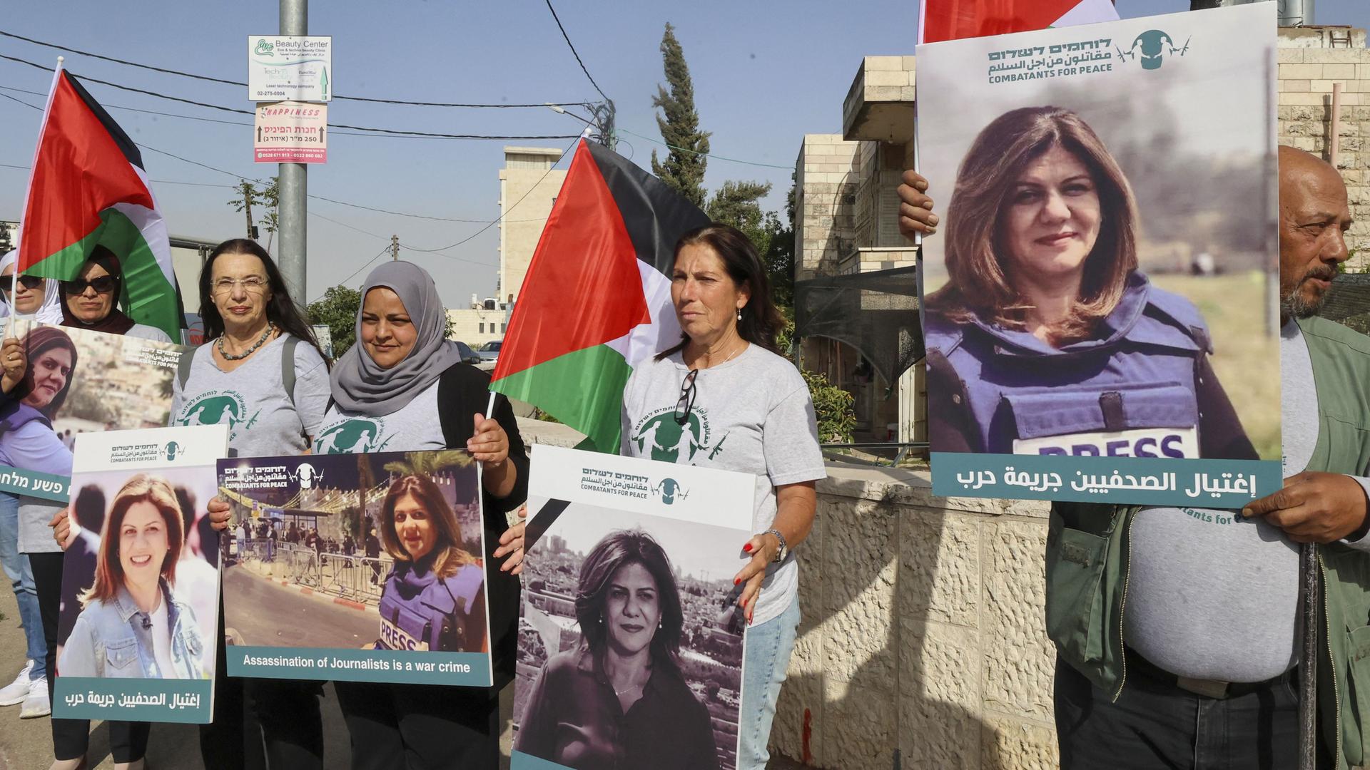 Palästinesische Demonstrierende und isralische Aktivisten der Bewegung "Combatants for Peace" tragen Plakate mit einem Porträt der getöteten Journalistin Shireen Abu Akleh.  