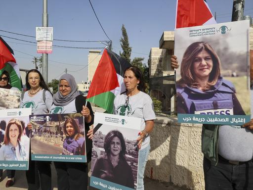 Palästinesische Demonstrierende und isralische Aktivisten der Bewegung "Combatants for Peace" tragen Plakate mit einem Porträt der getöteten Journalistin Shireen Abu Akleh.  