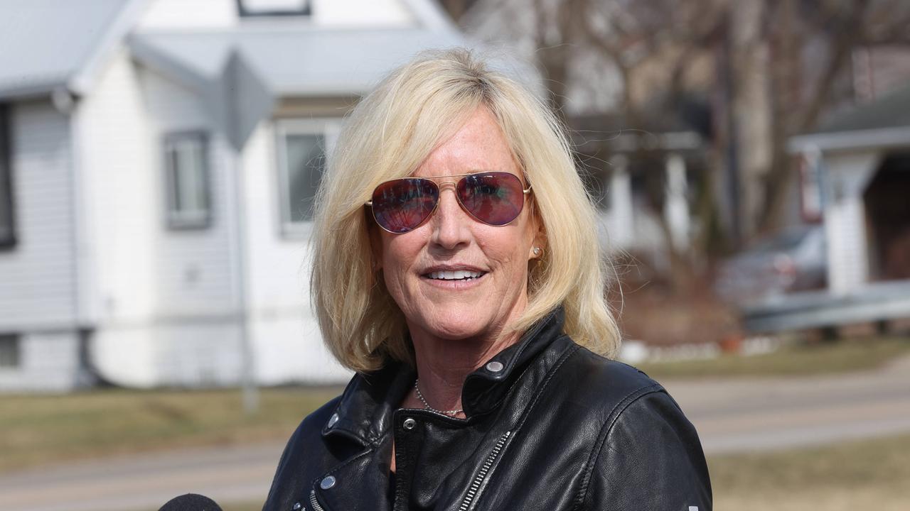 Erin Brockovich spricht mit den Medien im Vorfeld einer Bürgerversammlung in Ohio. Sie trägt eine Sonnenbrille und lächelt. 