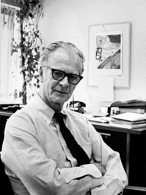 Schwarzweißaufnahme von B. F. Skinner in lockerer Pose in seinem Büro.