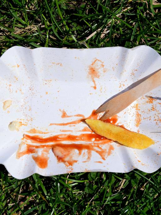 Im Bild eine leergegessene Pommes-Einweg-Pappschale mit Pieker an einem Badetag im Annabad. Symbolfoto, Themenfoto Hanover, 06.09.2024 
