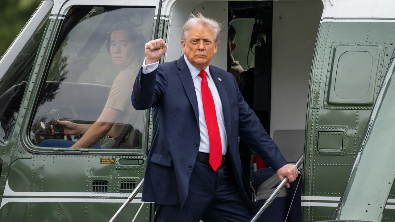 Donald Trump steht vor dem Einstieg eines Militärhubschraubers und reckt seine Faust in die Höhe.
