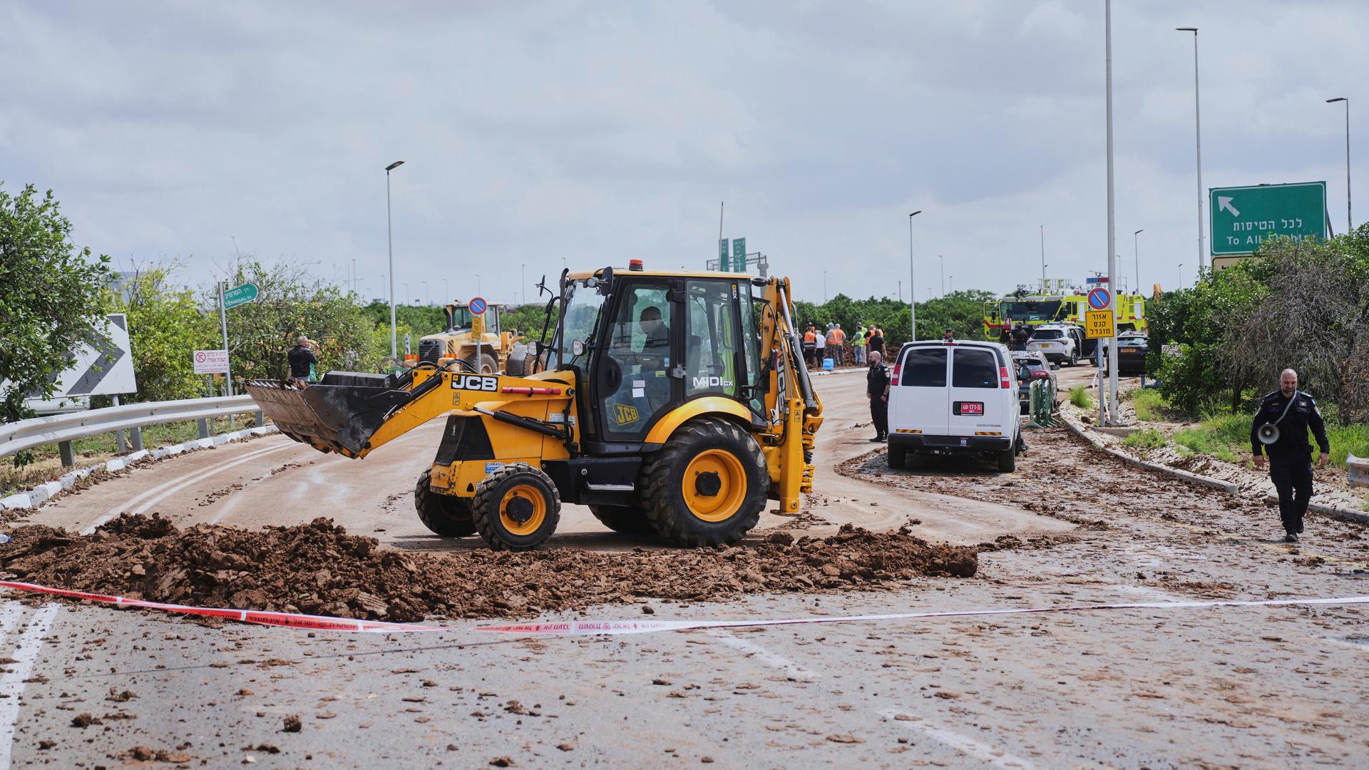 Eine Baumaschine räumt in der Nähe des internationalen Flughafens Ben Gurion bei Tel Aviv Trümmer von einer Straße. Eine Baumaschine räumt in der Nähe des internationalen Flughafens Ben Gurion bei Tel Aviv Trümmer von einer Straße.