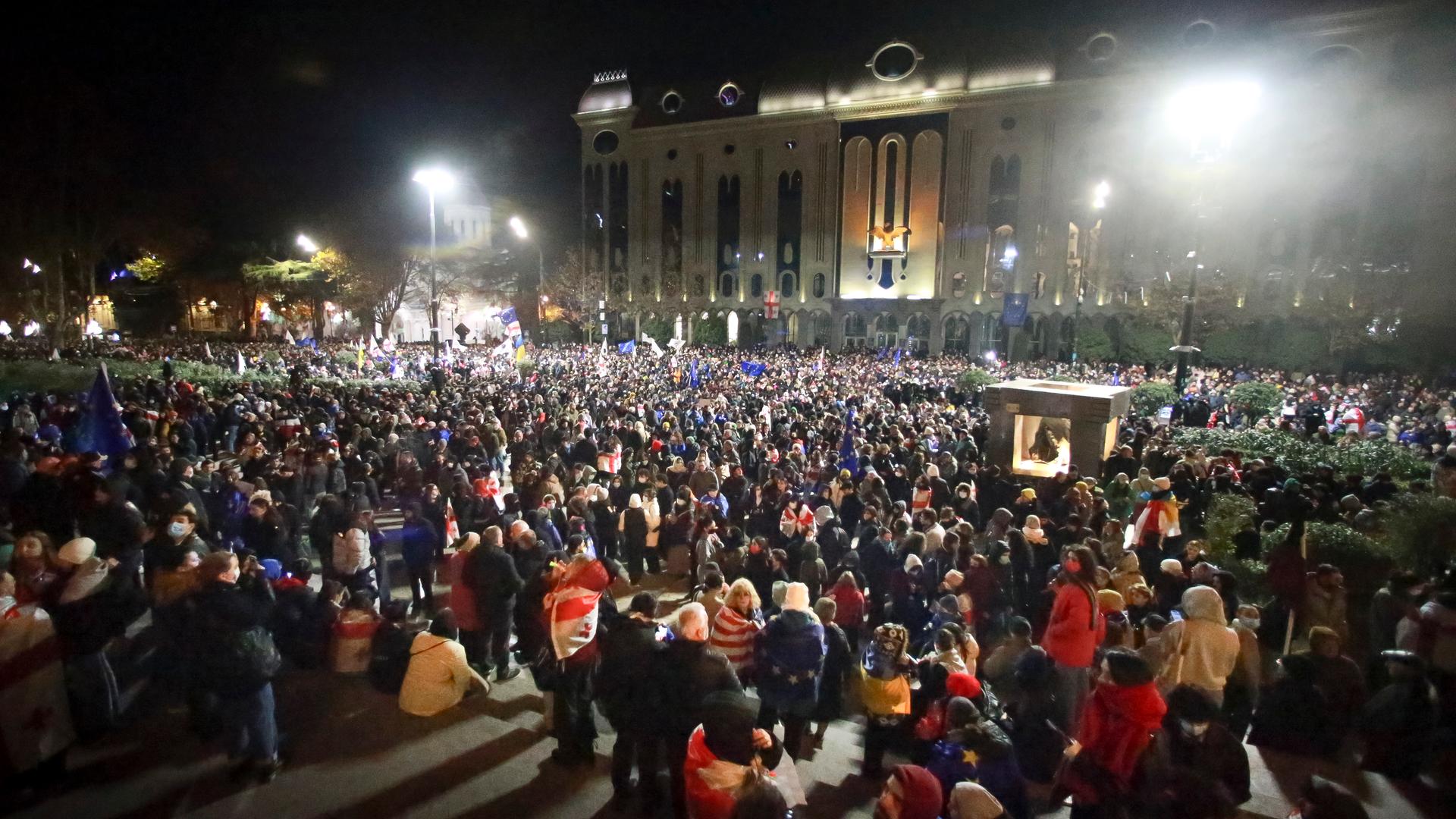 Tausende Demonstranten stehen am Abend vor dem Parlamentsgebäude in Tiflis.