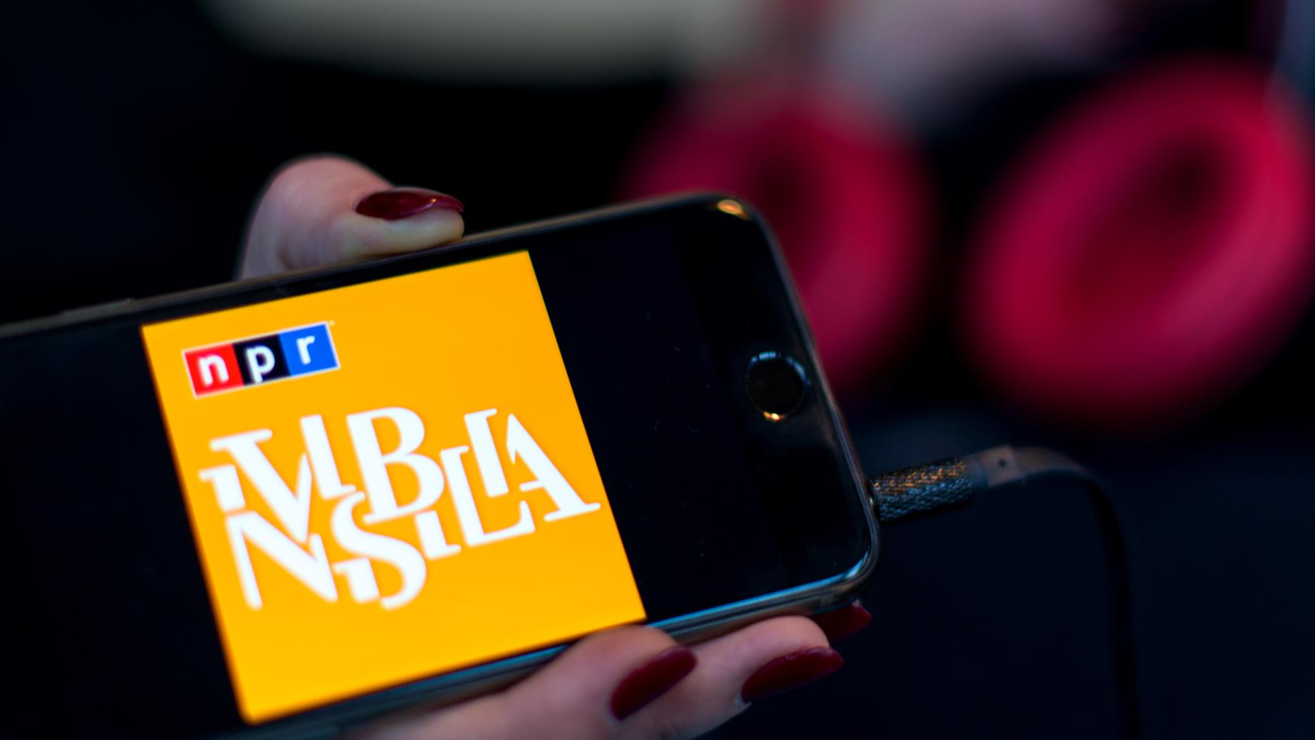 Eine Frauenhand hält ein Smartphone mit dem Icon der Podcast-App «Invisibilia» in der Hand. 