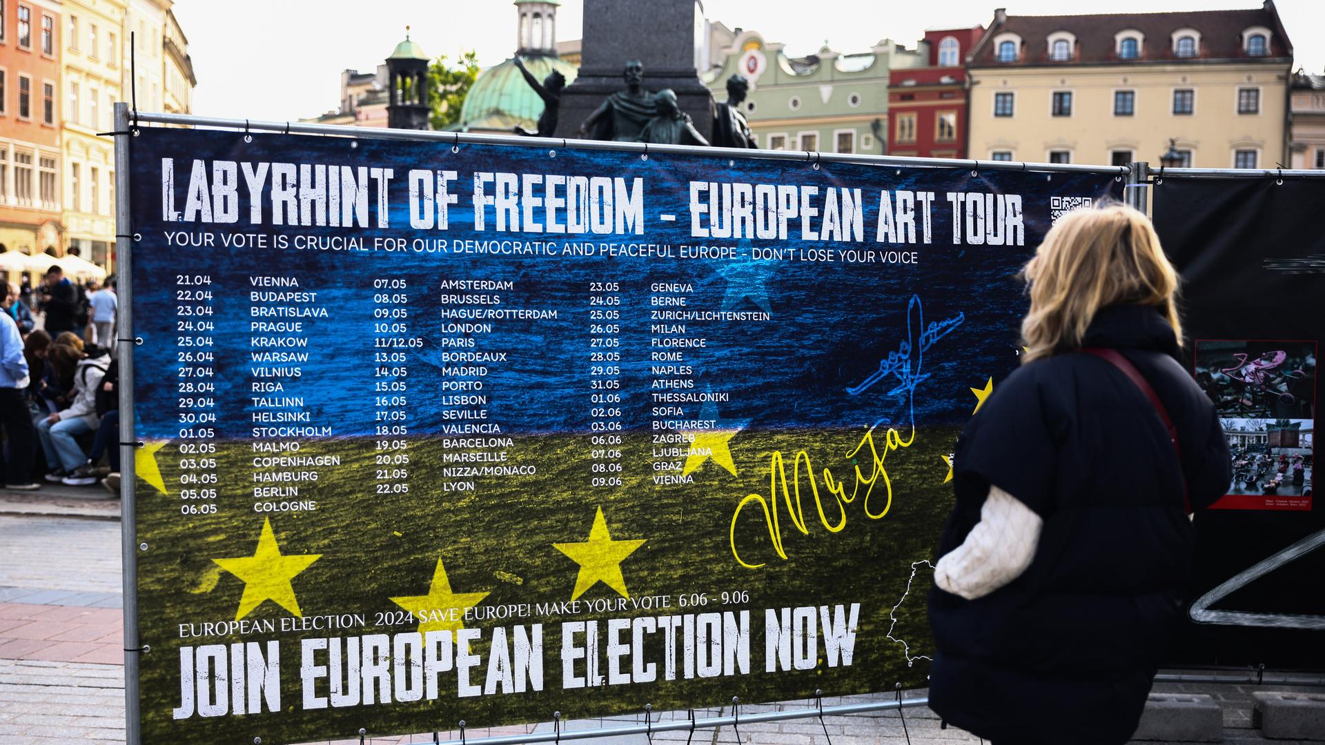 Polnische Passantin vor einem Plakat zu einer Kunstausstellung mit dem Titel: "Labyrinth Of Freedom - European Art Tour", die die Menschen zur Teilnahme an der EU-Wahl anregen will. 