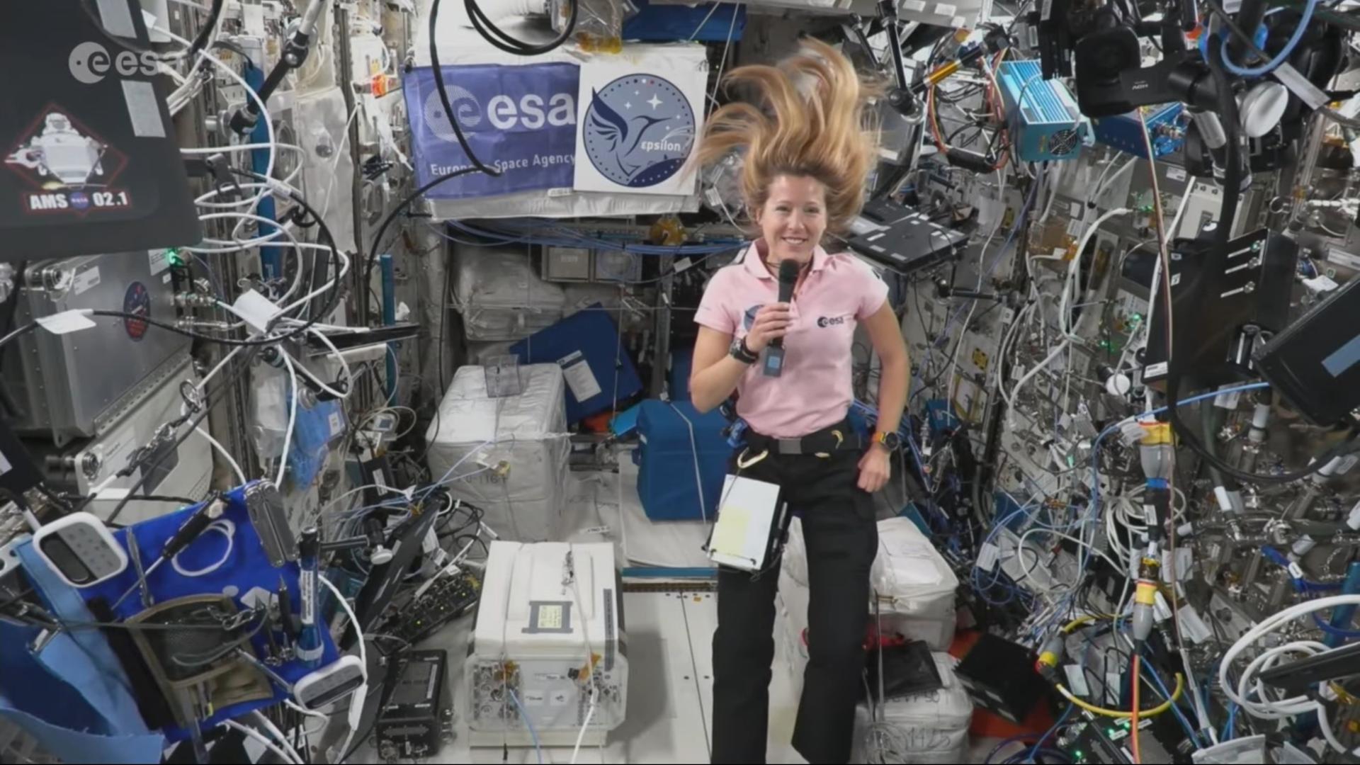 Astronautin Sophie Adenot in der Schwerelosigkeit der ISS, ihre langen blonden Haare schweben nach oben