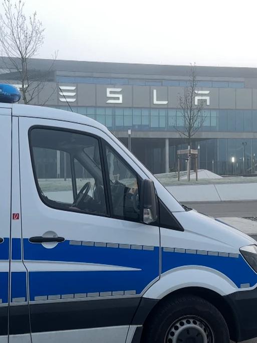 Ein  großes Fahrzeug der Polizei steht in den Morgenstunden auf dem Werksgelände von Tesla im brandenburgischen Grünheide.