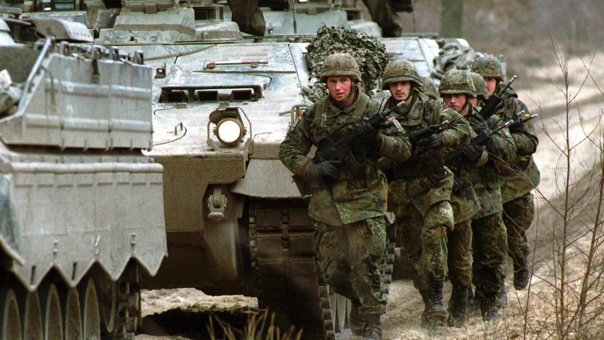 Bundeswehr: Soldaten des KFOR Kontingents fuer den Einsatz im Kosovo (GECONKFOR), hier neben einem Schuetzenpanzer Marder 1 A3