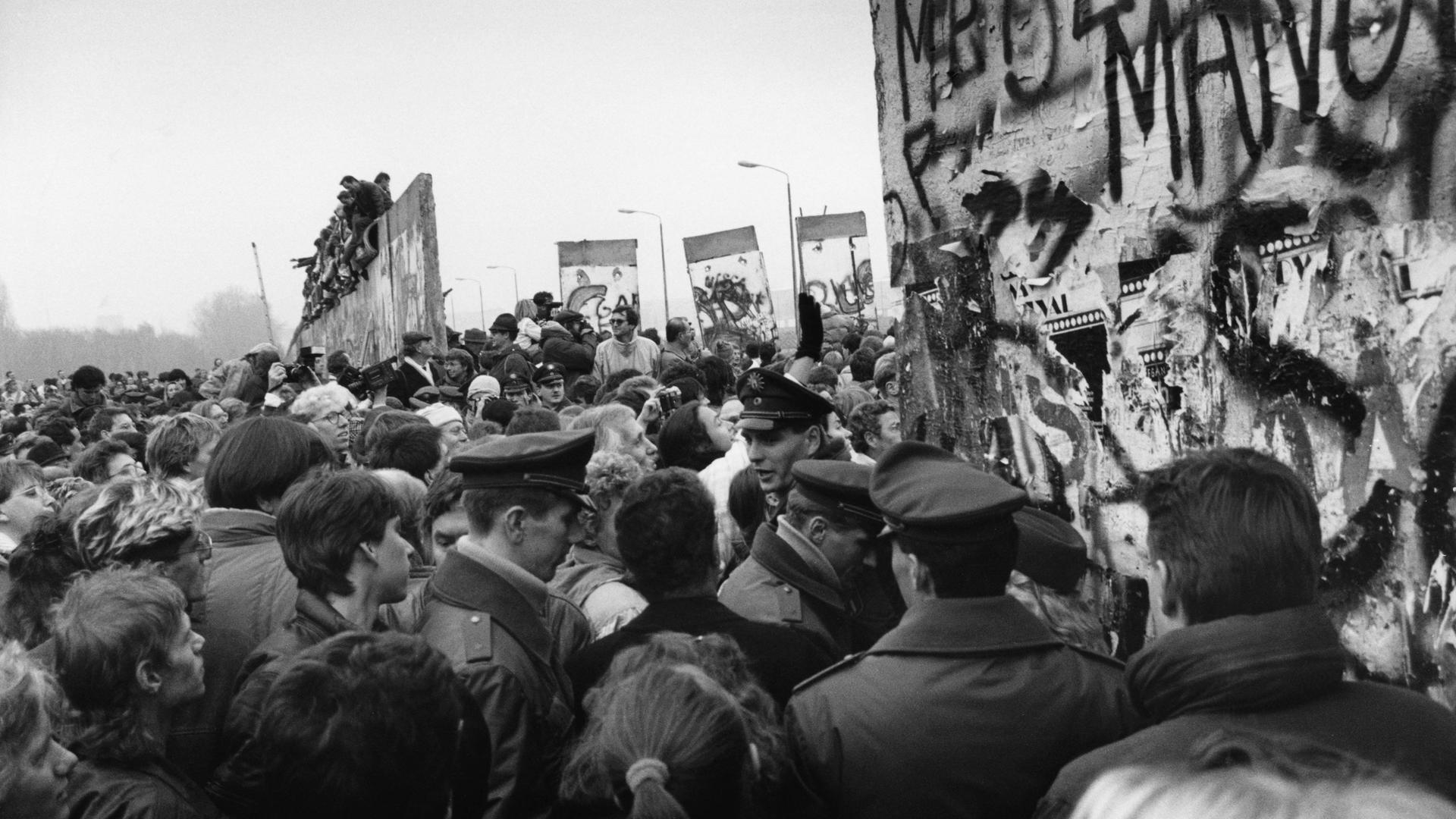 Tausende Menschen strömen dichtgedrängt durch einen Spalt in der Mauer nach Öffnung der DDR-Grenzen zum Westen in der Nacht vom 9./10. November 1989.