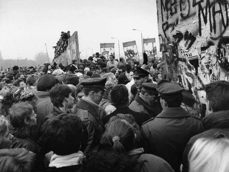 Tausende Menschen strömen dichtgedrängt durch einen Spalt in der Mauer nach Öffnung der DDR-Grenzen zum Westen in der Nacht vom 9./10. November 1989.