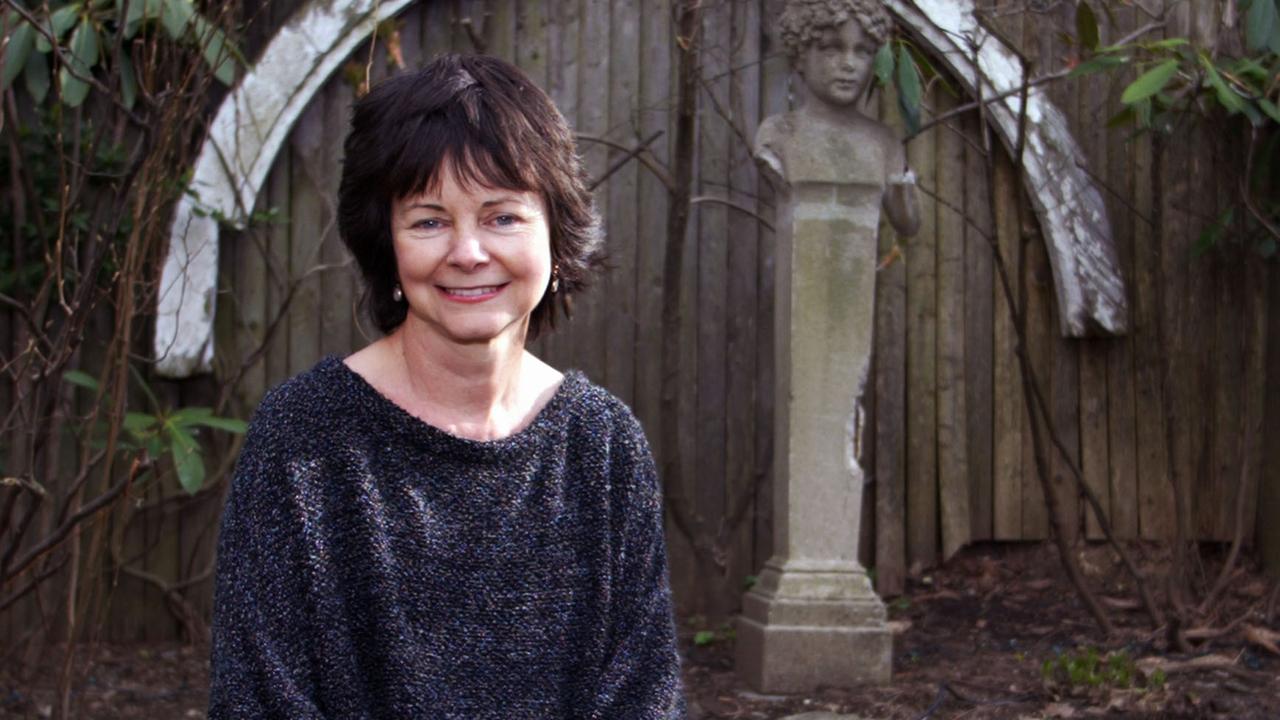 Die Schriftstellerin Geraldine Brooks sitzt vor einem Teich. Im Hintergrund steht eine Büste.