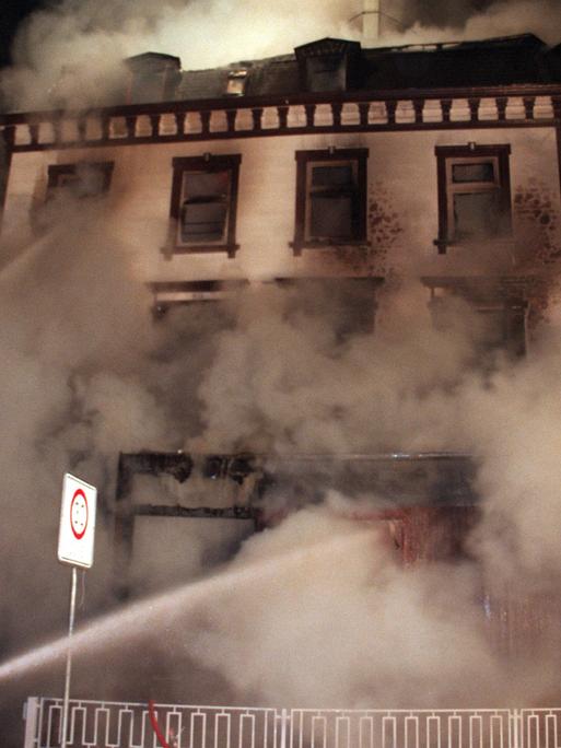 Feuerwehrmänner beim Löschen eines Feuers in einer Flüchtlingsunterkunft in Lübeck. Bei dem Brandanschlag sind am 18. Januar 1996 zehn Menschen getötet worden.